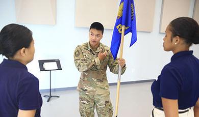 Sean Kelly holds a flag as part of a ROTC activity